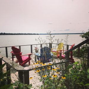 Chairs on a deck by the lake could be your Bay of Quinte backyard.