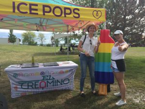 Two people standing in front of a tent that says 'El Creamino'.