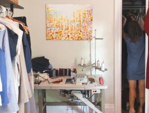 A sewing table and rack of clothing at Heather Case's studio.