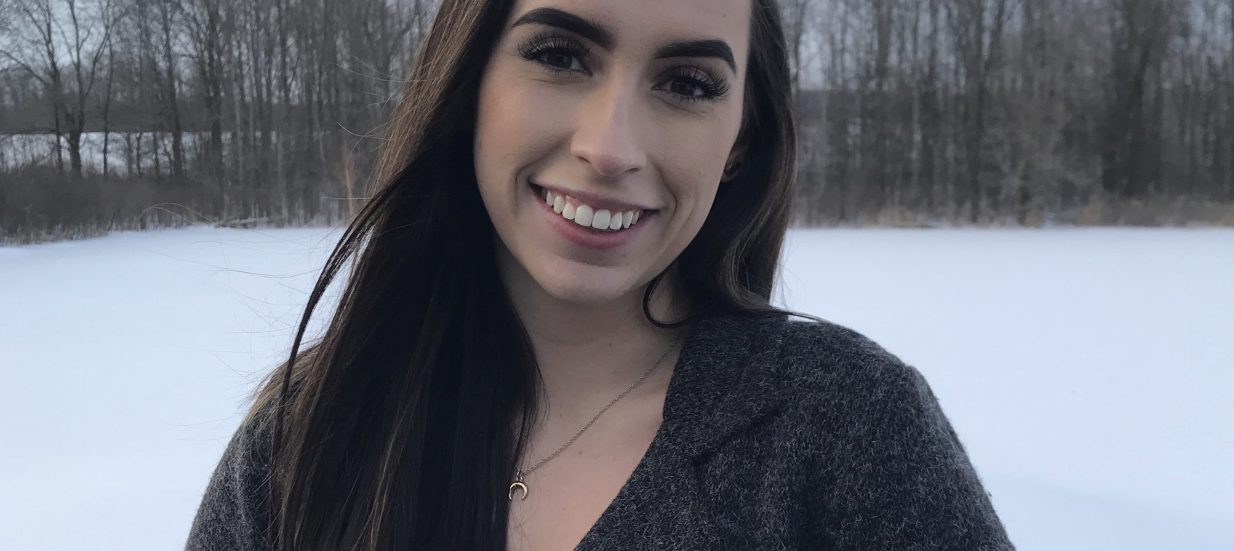 Mika Henry, a social media strategist, standing outside with snow and trees behind her.