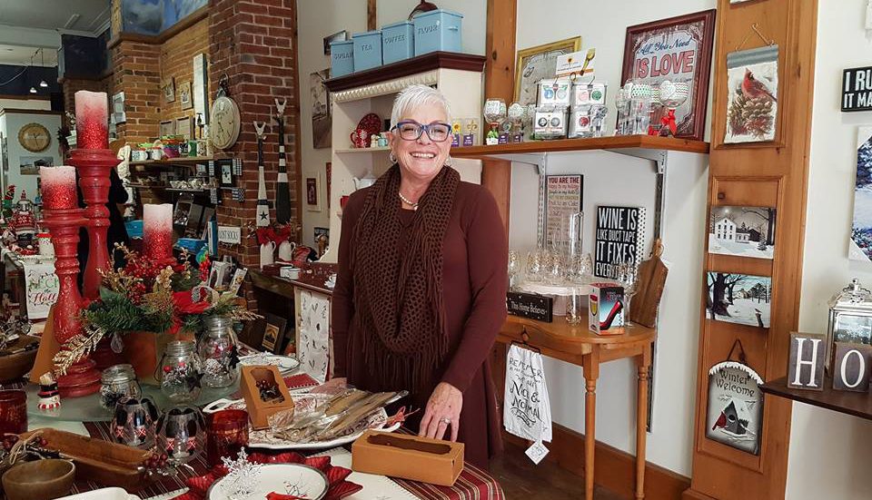 A woman standing in a store at Christmas time.