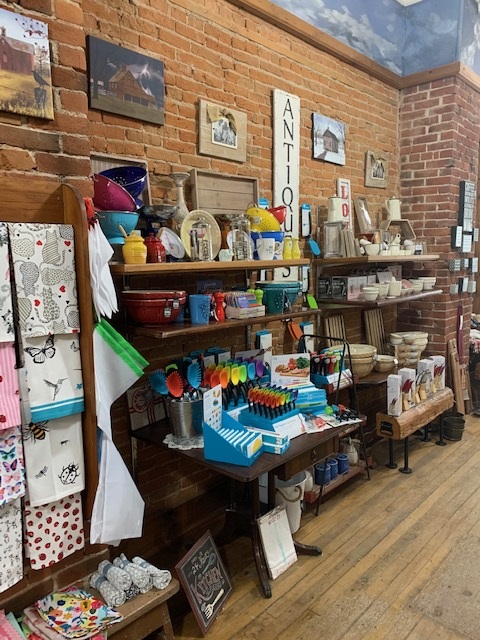 A brick wall with shelves of kitchen supplies at a store.