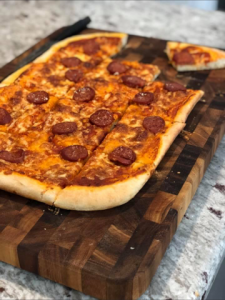 Pepperoni pizza by Dough Mama on a cutting board.