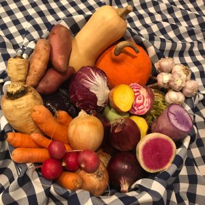 A pile of mixed produce on a black-and-white checkered blanket.