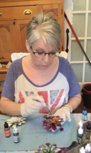 A woman painting at a table.