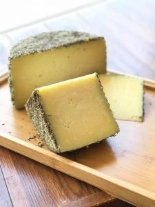 A block of cheese on a wooden board.