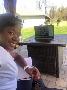 A woman sitting outside on a patio with her computer.