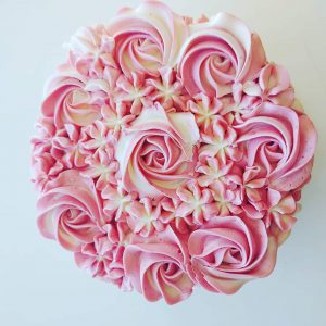 The top of a cake with swirly pink icing.