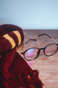 A scarf and eyeglasses on a table.