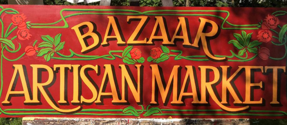 A hand-painted sign with text: Bazaar Artisan Market. Kaya Pereira, owner and curator of the Bazaar Artisan Market in downtown Belleville.