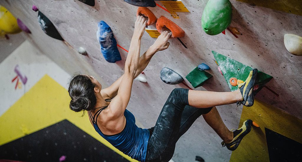 Female rock climbing indoors