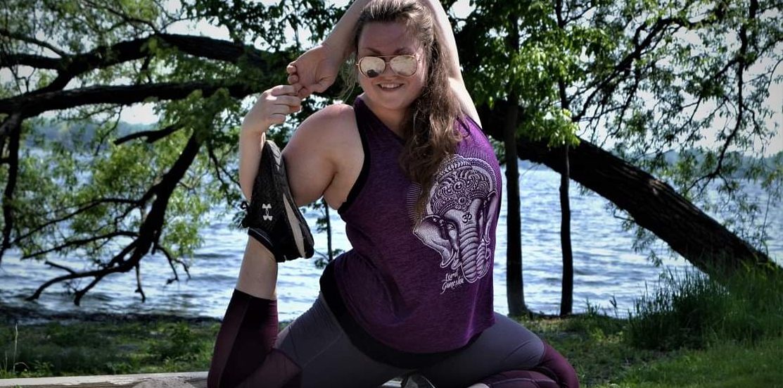 A person doing a yoga pose in front of a tree.