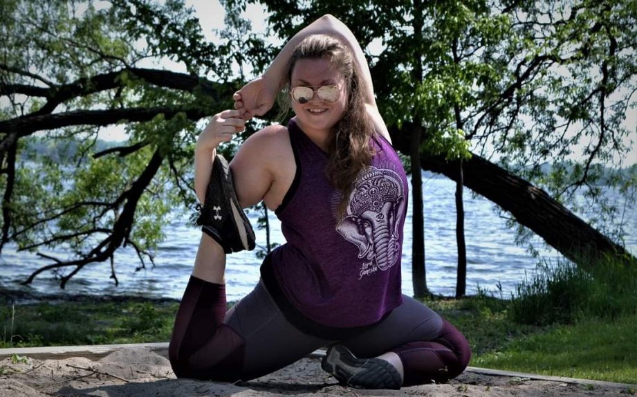 A person doing a yoga pose in front of a tree.