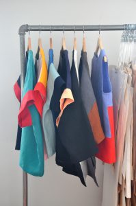 Colourful shirts hanging on wooden hangers.