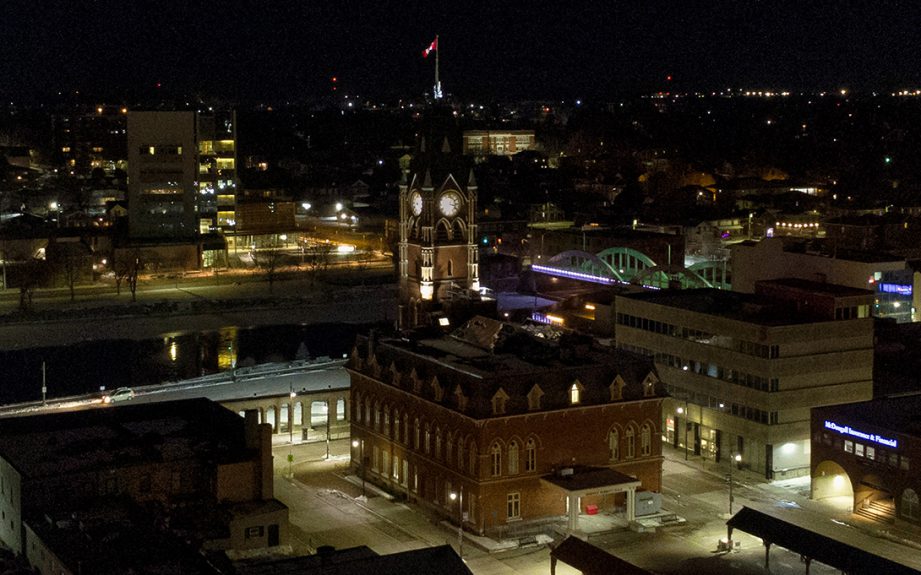 An aerial photo of a tall redbrick building, Belleville City hall, at night.