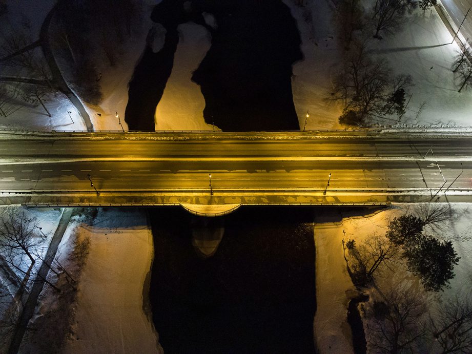 Aerial photo at night of a road crossing over a river.