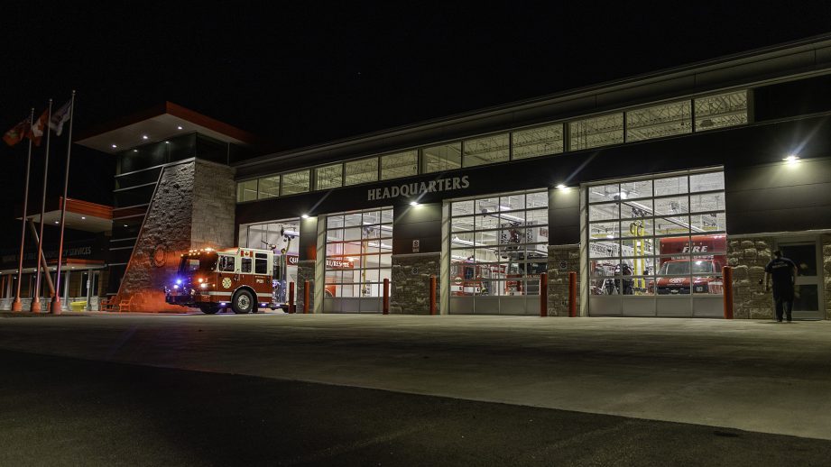 A fire department at night with lights on.