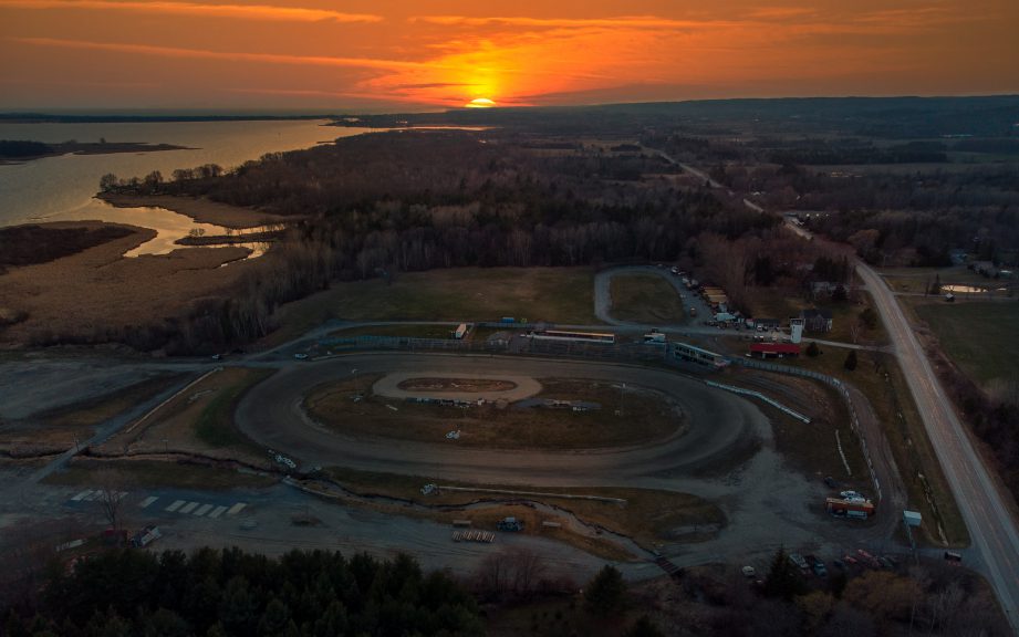 Aerial photo of a race track with a sunrise in the background.