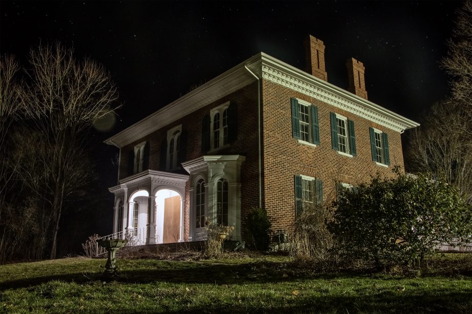 An old red-brick house at night.