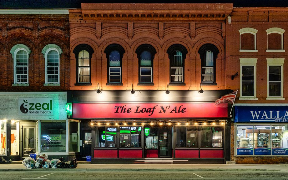 A row of businesses with red-brick building above.