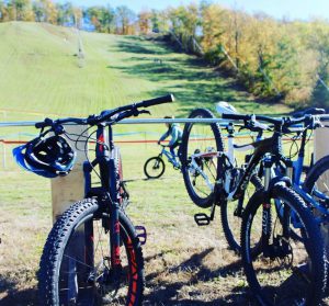 Bikes at the bottom of a grassy hill.