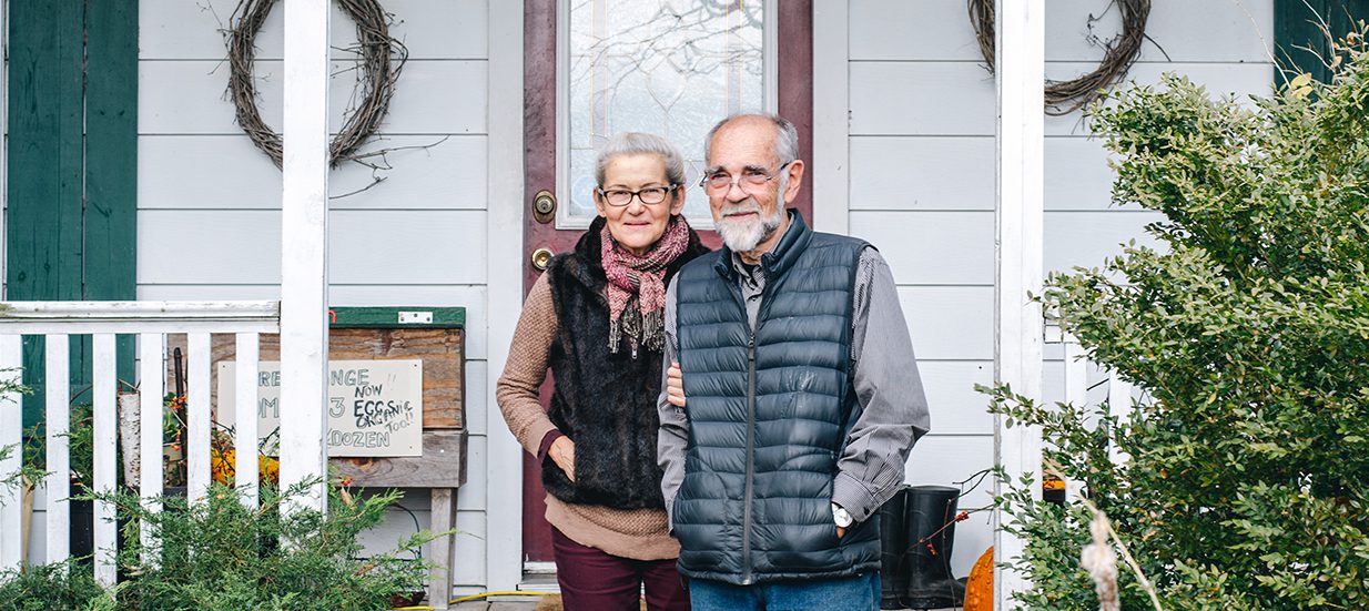 Audrey and James Potts, owners of Palliser Downs Farms in Quinte West, standing side by side on their front porch.