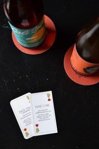 Two bottles of beer and business cards from Wild Card Brewing Co.