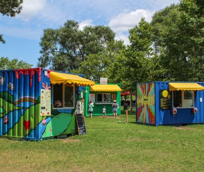 colourfully-painted shipping containers filled with food vendors in west zwick's park at pop-ups on the bay